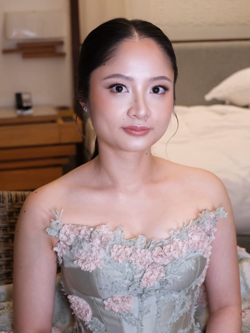 Woman in a floral dress with a sleek centre-parted low bun