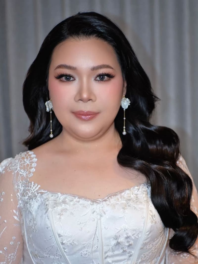 Bride with soft waves swept to one side and drop earrings