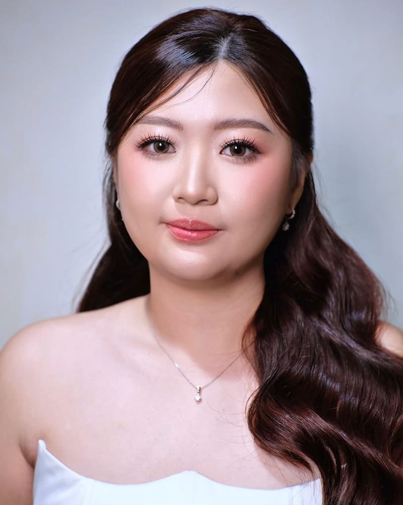 Woman in a white strapless dress with half-up waves