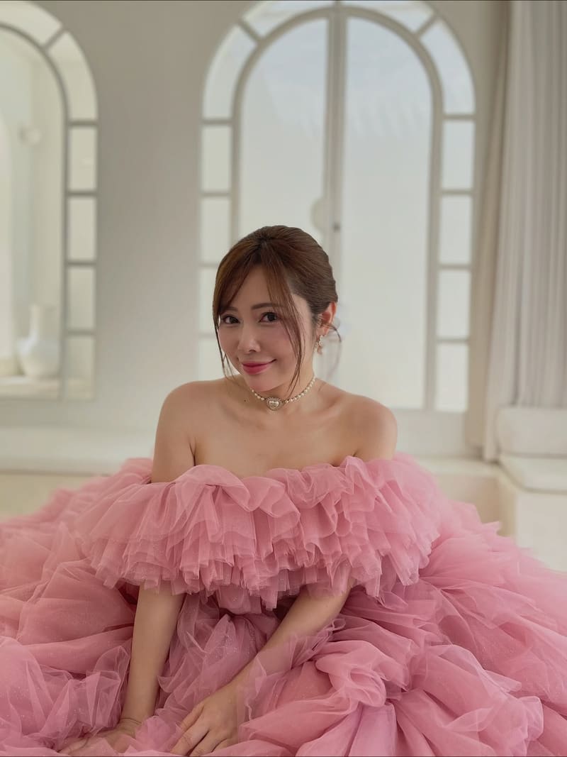 Woman in a pink tulle gown with a loose updo and a fringe