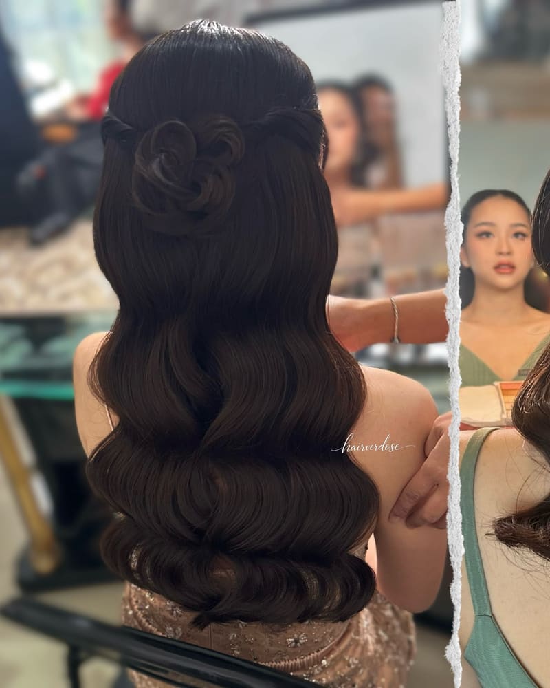 Long glossy waves seen from behind, with a twisted rose at the crown